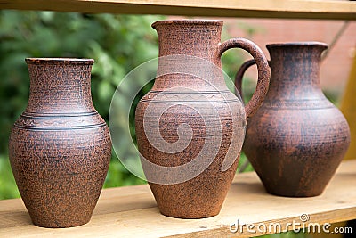 Three clay jars without frosting on the table at the fair of masters Stock Photo