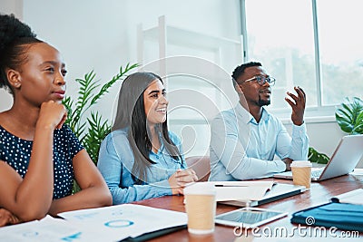 Three colleagues in business meeting around conference table, discuss solutions Stock Photo