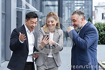 colleagues employees watch funny videos or look at photos, pictures memories looking at smartphone Stock Photo