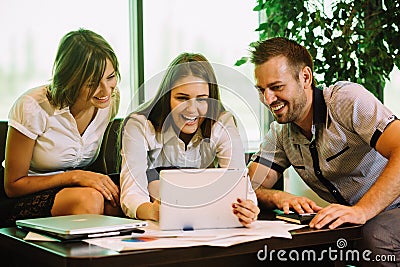 Three colleagues at the office taking selfies sitting on the couch Stock Photo