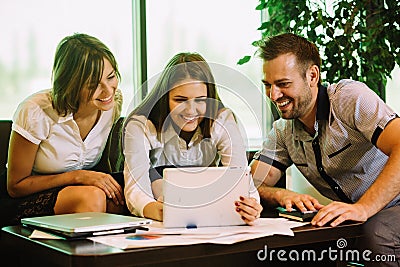 Three colleagues at the office taking selfies sitting on the couch Stock Photo