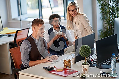 Three colleagues watching and analyzing content at computer monitor in office. casual modern business Stock Photo