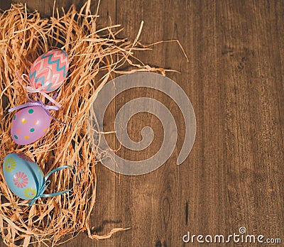 Three colored easter eggs on bed of straw Stock Photo