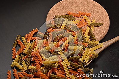 Three Colors Rotini Pasta. Twisted colored pasta in Italy. On a black background Stock Photo