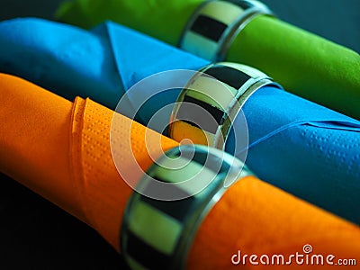 Three coloured serviettes in napkin rings Stock Photo