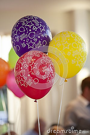 Three colourful 18th birthday party balloons, red and purple and yellow, at a party Stock Photo