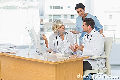 Three concentrated doctors using computer together Stock Photo