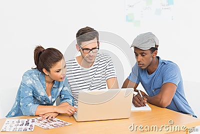 Three concentrated young artists working on laptop Stock Photo