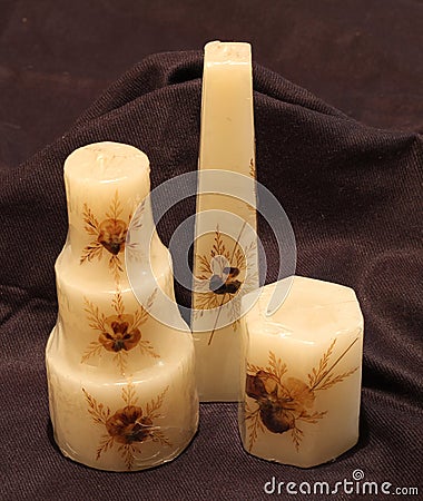 Three cream color candles of various design Stock Photo