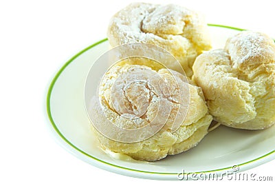 Three cream puffs on white plate closeup Stock Photo