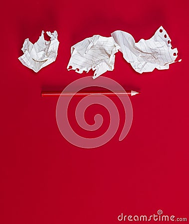 Three crumpled white pieces of paper and a red wooden pencil on a red background Stock Photo