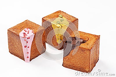 Three cube shaped croissants with creamy berry glaze, pistachio sauce and chocolate ganache Stock Photo