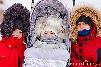 Three cute children in winter jackets and hoods with fluffy winter fur Stock Photo