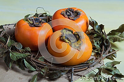 Three delicious caquis on the table Stock Photo