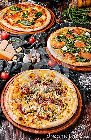 Three Different Pizzas on wooden table Stock Photo