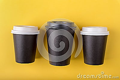 Three disposable paper black cups different sizes with close plastic lids for takeout coffee, which is then recyclable Stock Photo