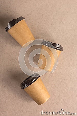 Three disposable paper cups for coffee on a beige background. Takeaway coffee concept Stock Photo