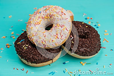 Three donuts, one on top of another, chocolate and white cream on turquoise wooden background Stock Photo