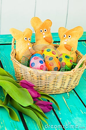 Three easter bunnies with colored easter eggs on a wooden tabel Stock Photo