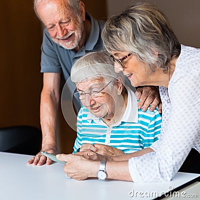 Three elderly persons using smart phone Stock Photo