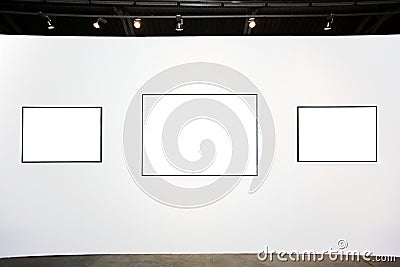 Three empty frames on white wall Stock Photo