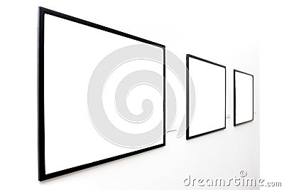 Three empty frames on white wall Stock Photo