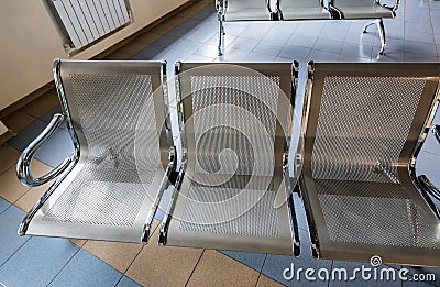 Three empty seats in waiting area of airport Stock Photo