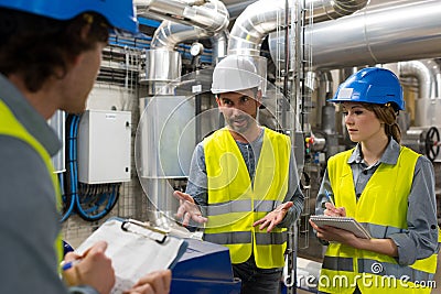 Three engineers talking in factory Stock Photo