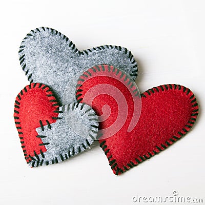 Three felt hearts on a white wooden background Stock Photo