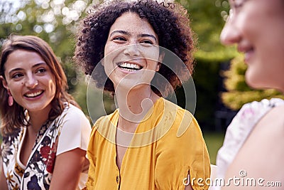 Three Female Friends Sitting Outdoors Together And Catching Up In Summer Garden At Home Stock Photo