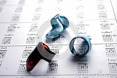 Three finger picks on a guitar chord tablature background Stock Photo