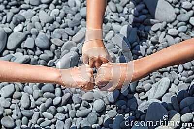 Three fist hands children centre on the beach. Stock Photo