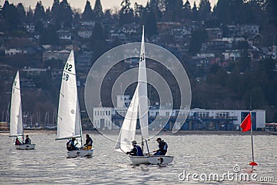 Three FJ sailboats competing in a regatta sail into shore Jericho Beach Editorial Stock Photo