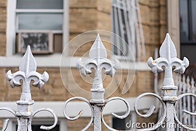 Three Fleur De Lis Points on a White Home Fence Stock Photo