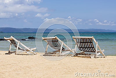 Three folding beach chairs on the beach with sea and bright sky in the background at Koh Mak in Trat, Thailand. Seasonal Vacation Stock Photo