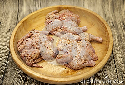 Three fresh raw chicken on a wooden tray with lemon and chilli on the wooden background Stock Photo