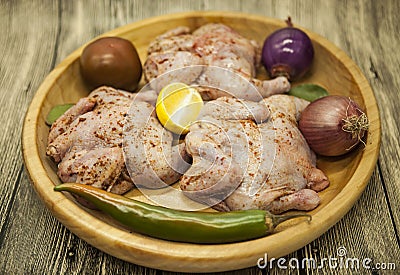 Three fresh raw chicken on a wooden tray with lemon and chilli on the wooden background Stock Photo