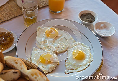 Three fried eggs on white plate for breakfast Stock Photo
