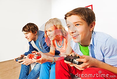 Three friends with joysticks playing game console Stock Photo