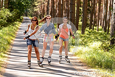 Three friends on in-line skates outdoor Stock Photo