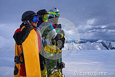 Three friends look forward snowboarders courageously Stock Photo