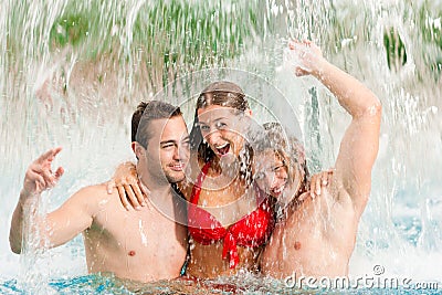 Three friends in public swimming pool Stock Photo