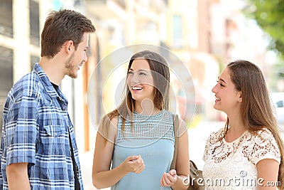 Three friends talking taking a conversation on the street Stock Photo