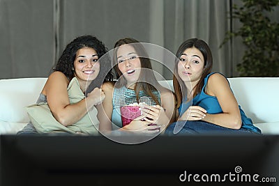 Three friends watching romantic movie on tv Stock Photo