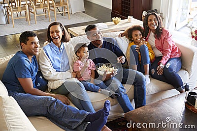 Three generation family African American family sitting on the sofa in living room, watching TV and eating popcorn together, elev Stock Photo