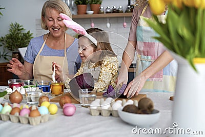Three generation of women preparation natural dyes for coloring eggs Stock Photo