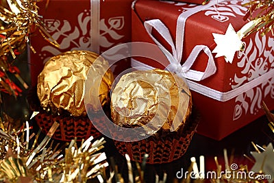 Three gift boxes and two luxury golden sweets Stock Photo
