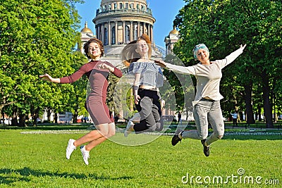 Three girls coeds have fun jumping on the background of St. Isaa Stock Photo