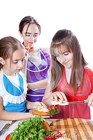 Three girls of the cook prepare a vegetarian dish Stock Photo