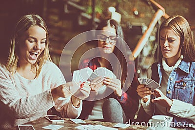 Three girls at home playing cards. Stock Photo